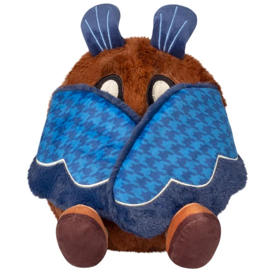 Mini Mothman Squishable hiding behind its folded blue houndstooth wings, showing its eyes, antennae and feet.