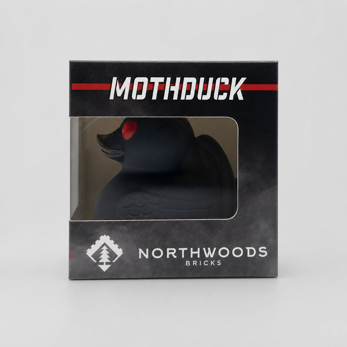 Boxed Northwoods Bricks Mothduck, a black Mothman-inspired rubber duck collectible featuring red eyes, horns and wings.